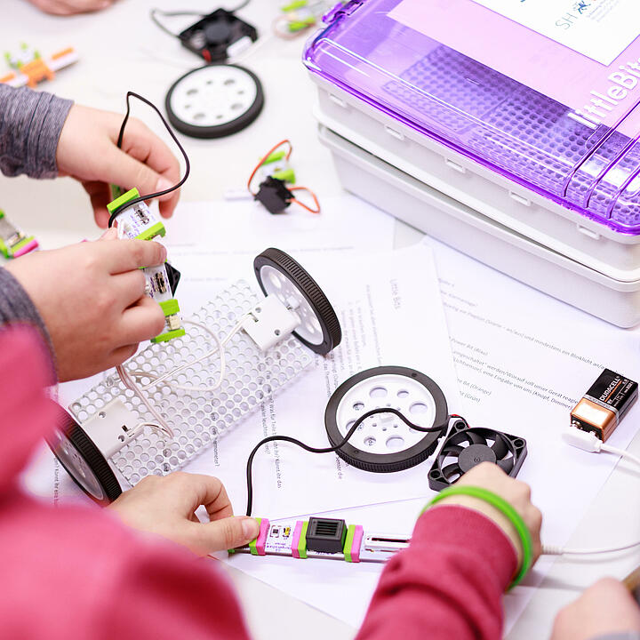 Über die Schultern von zwei Kindern sind Bestandteile eines mobilen Makerspaces zu sehen.